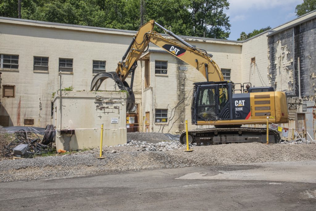 Photo showing a material handler being used to begin demolition on an ancillary facility outside the Criticality Experiment Lab