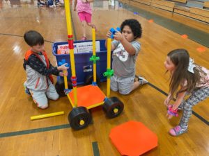 Photo: three students at Claxton Elementary put finishing touches on their TubeLox racing car built with materials purchased with UCOR mini-grant funds