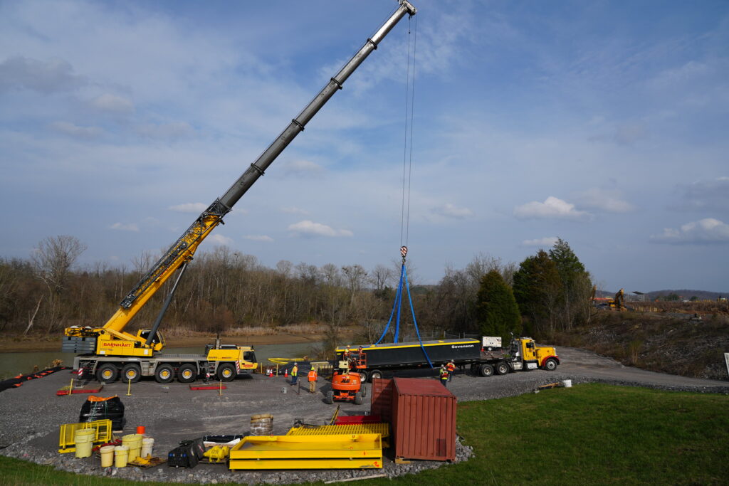 Workers at the East Tennessee Technology Park load a barge into the river