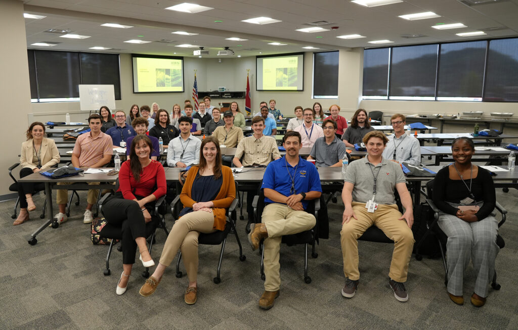 Photo of 2023 intern students seated at tables during orientation.
