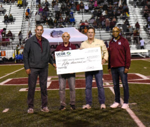 Photo of big check presentation to Oak Ridge High School athletics on the field at ORHS football game.