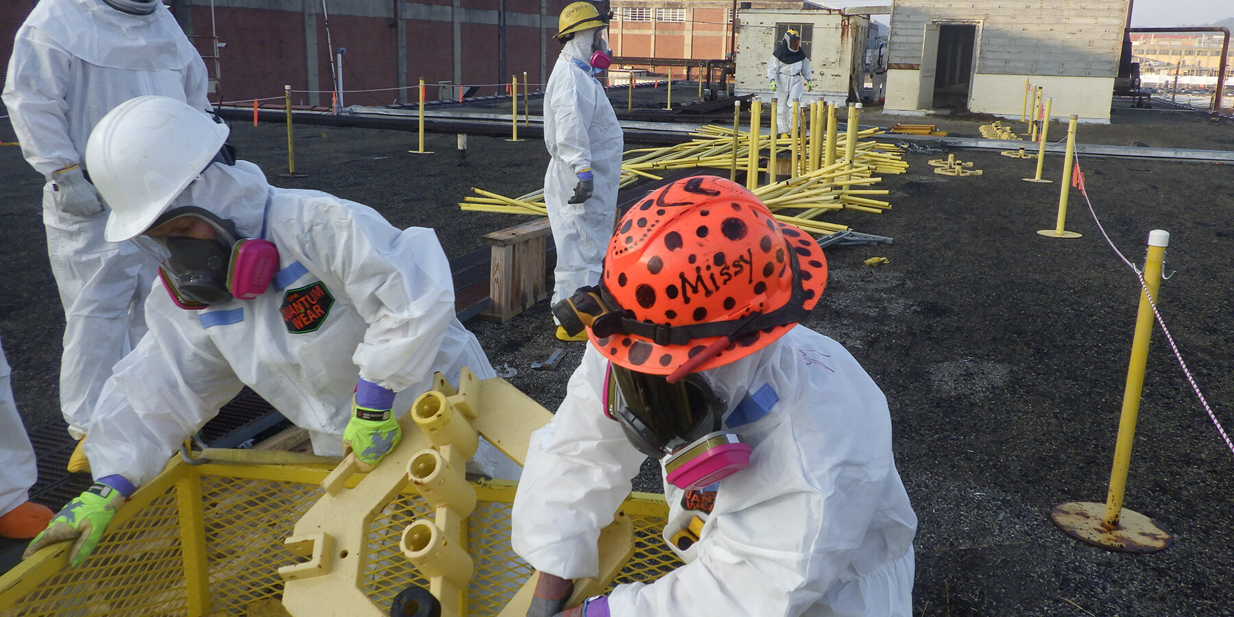 Alpha-2 workers removing transite from "dog houses" on the roof.