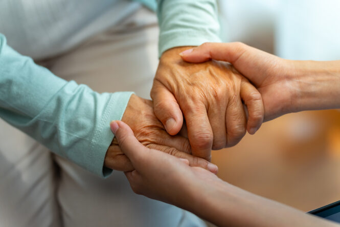 Stock photo of hands of two women clasped