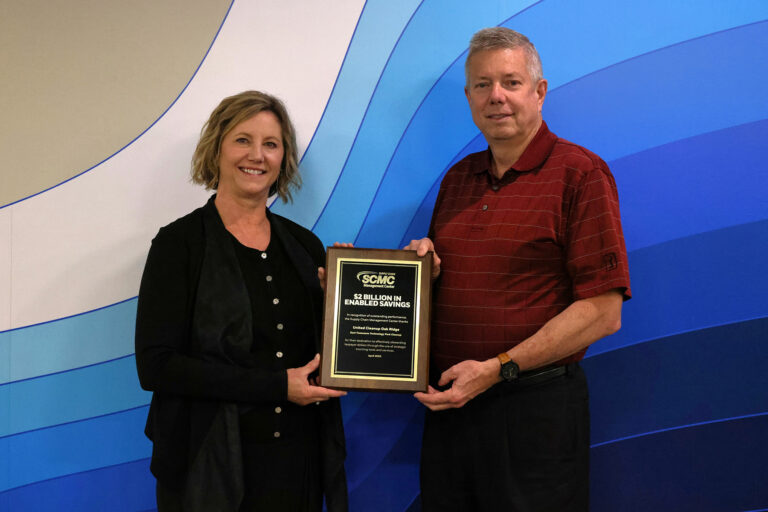 Kala Dickerson and Jeff Burgan display the award plaque received from the DOE Supply Chain Management Center.